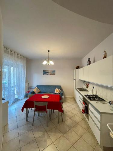 a kitchen and living room with a table and a couch at Appartamento ' Il sole di Vale' in Loano