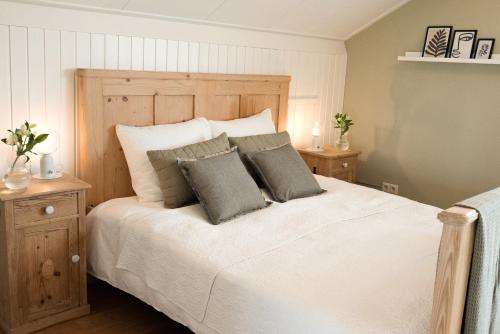 1 dormitorio con 1 cama blanca grande y 2 almohadas en Samen Delen, en Waarland