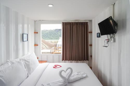 a bedroom with a bed with two hearts on it at Container Smart Stay CSS in Bedugul