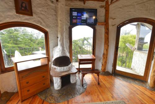 a living room with a fireplace and two windows at Casa Cuento in Concón