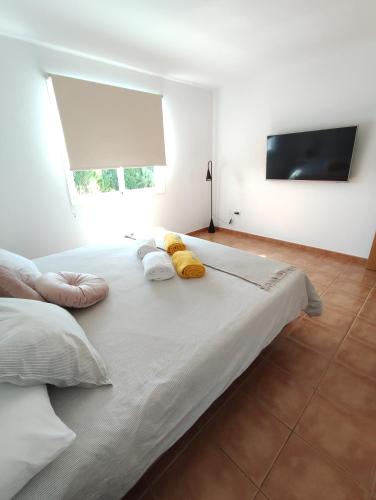 a large white bed with two pillows and a television at Casa Bermeja - Tiscamanita in Tiscamanita