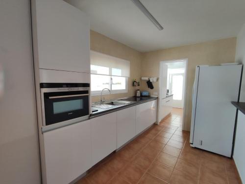 a kitchen with white cabinets and a white refrigerator at Casa Bermeja - Tiscamanita in Tiscamanita