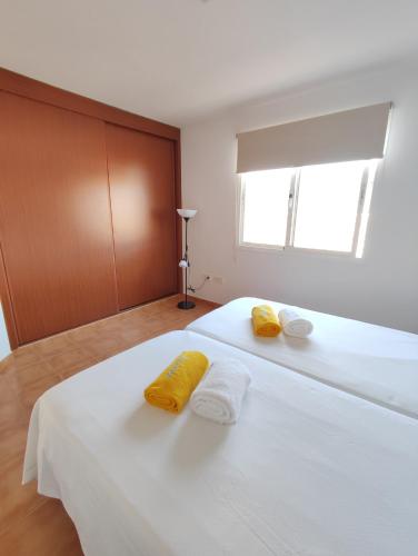 a bedroom with a large white bed with yellow pillows at Casa Bermeja - Tiscamanita in Tiscamanita