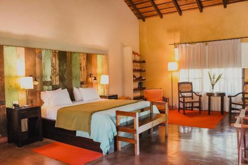 a bedroom with a large bed and a table and chairs at Reserva Natural Iguazú - Posada Puerto Bemberg in Puerto Libertad