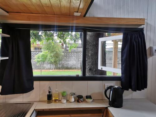 a window with black curtains in a kitchen at Loft a pasos del centro con estacionamiento in Los Ángeles