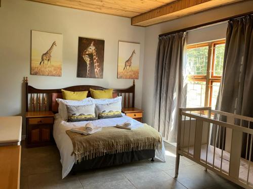 1 dormitorio con 1 cama con 2 jirafas en la pared en Family unit, en Kromriver
