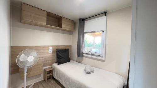 a small bedroom with a bed and a window at Mobil-Home Les Lauriers Roses Camping Siblu 4**** in Fréjus