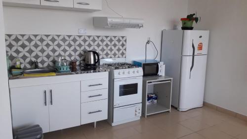 a kitchen with a white stove and a refrigerator at MyR alojamiento in Ushuaia