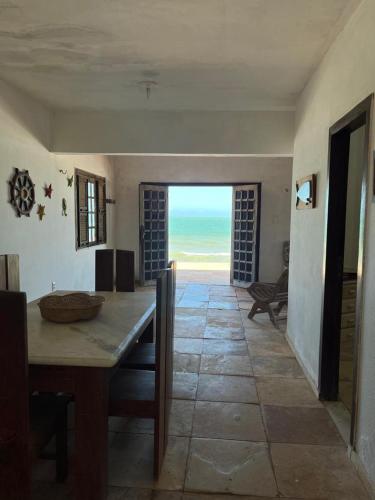 a dining room with a table and a view of the ocean at Beach Place Fontainha in Aracati