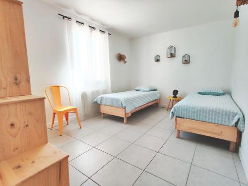 マロセーヌにあるLe Mas des 3 Tilleulsのベッドルーム1室(ベッド2台、椅子付)