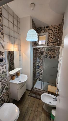 a bathroom with a toilet and a sink and a shower at Testa o Croce Casa Vacanze in Matera