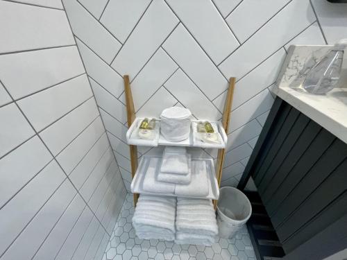 a bathroom with a sink with towels on a shelf at Salt Loft - Oceanfront, Hot Tub And Firepit! in Ucluelet