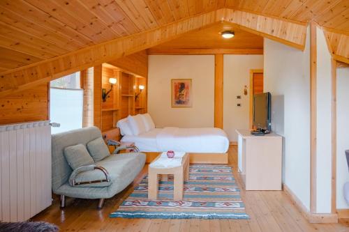 a bedroom with a bed and a couch and a tv at Natyral Razma Resort in Razëm