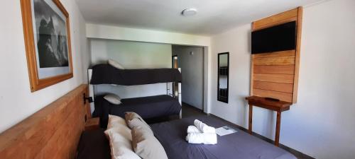 a bedroom with a bed and a bunk bed at Huella Andina in San Carlos de Bariloche