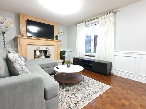 sala de estar con sofá y mesa en Deluxe Private Room in North York en Toronto