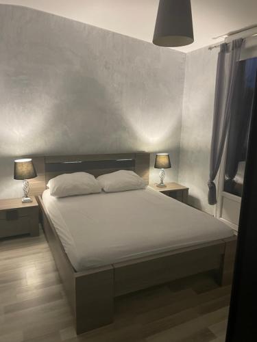 a bedroom with a bed with two lamps on two tables at Piscine ET JACUZZI ST GEORGES DE DIDONNE a 1km de la plage in Saint-Georges-de-Didonne