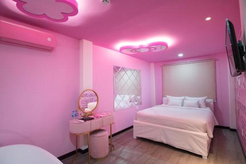 a pink bedroom with a bed and a mirror at Language Exchange Hotel 3 in Ho Chi Minh City