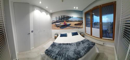 a room with a couch with a beach mural on the wall at Apartamenty S&S Olympic Park Kołobrzeg A208 in Kołobrzeg