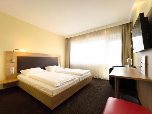 a hotel room with a large bed and a window at Ott's Hotel Weinwirtschaft & Biergarten Weil am Rhein/Basel in Weil am Rhein