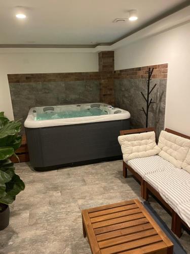 a jacuzzi tub in a living room with two couches at Apartmány U Lípy in Tatobity