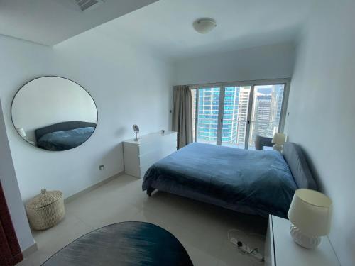 a bedroom with a blue bed and a mirror at One bedroom apartment with pool & gym near Marina in Dubai