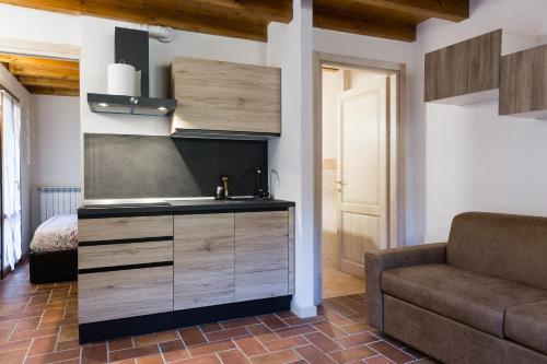 una cocina con fregadero y un sofá en una habitación en Piccolo Chalet, en Ponte di Legno