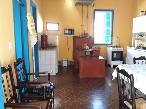 una cucina e una sala da pranzo con tavolo e sedie di Casa estilo colonial, no Centro de Aiuruoca-MG. a Aiuruoca