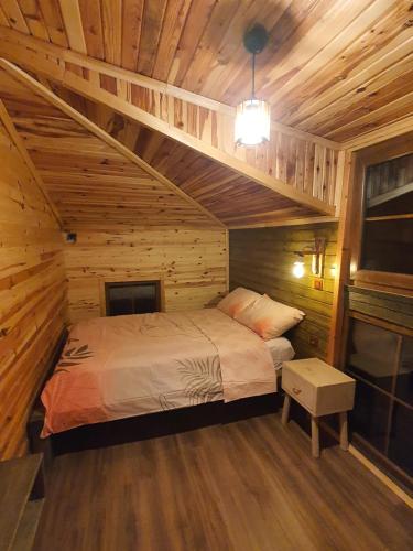 a bedroom with a bed in a wooden cabin at Gesatona Angel House in Fındıklı