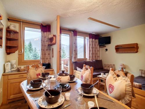 une cuisine et un salon avec une table et des chaises dans l'établissement Appartement skis aux pieds à Reberty 1850 avec balcon, 2 pièces, 4ème étage, bord de piste - FR-1-344-826, aux Menuires
