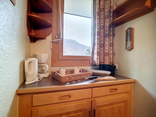 un comptoir de cuisine avec un évier et une fenêtre dans l'établissement Appartement skis aux pieds à Reberty 1850 avec balcon, 2 pièces, 4ème étage, bord de piste - FR-1-344-826, aux Menuires