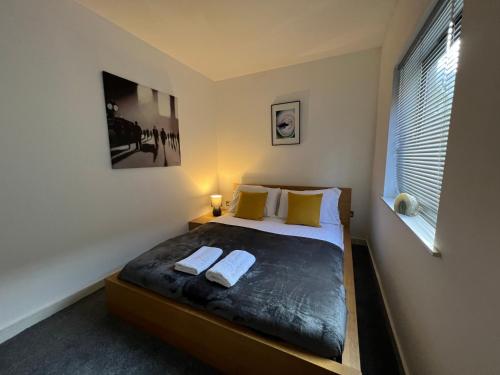 a bedroom with a bed with two towels on it at Beautiful Loft City Centre, Liverpool 1 in Liverpool