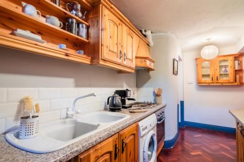 a kitchen with a sink and wooden cabinets at Mill Cottages at Kilcarbry House in Enniscorthy