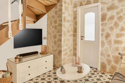 a living room with a tv and a white dresser at Estia Residence in Chania Old Town in Chania