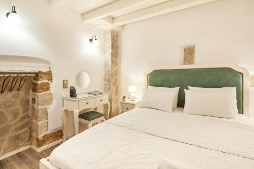 Un dormitorio con una gran cama blanca con cabecero verde. en Estia Residence in Chania Old Town, en La Canea