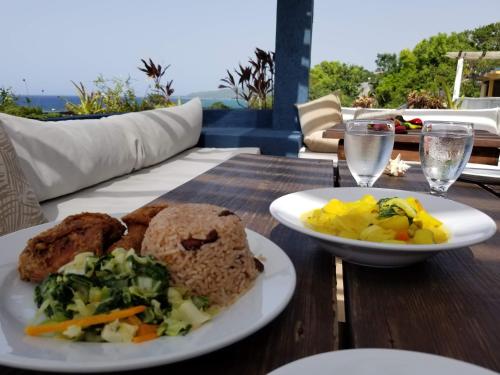 a table with a plate of food and a bowl of vegetables at Moxons Beach Club in Boscobel