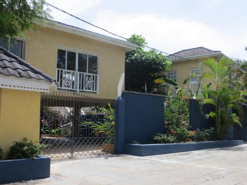 a house with a blue gate and some plants at Moxons Beach Club in Boscobel