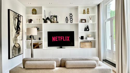sala de estar con TV y estanterías blancas en New stylish 1 bedroom apt w/ 2 balconies in Centrum en Ámsterdam