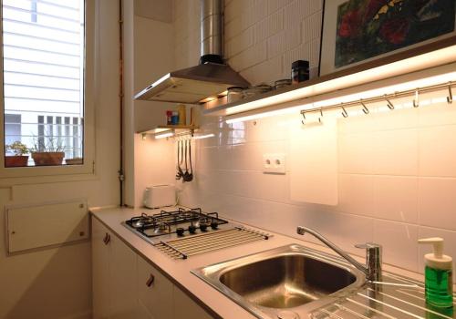 a kitchen with a sink and a stove at Casa entera e independiente con parking en pleno centro de Sevilla in Seville