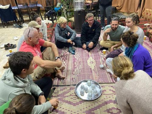 a group of people sitting around on the ground at Ein lahda camp-site in Dana