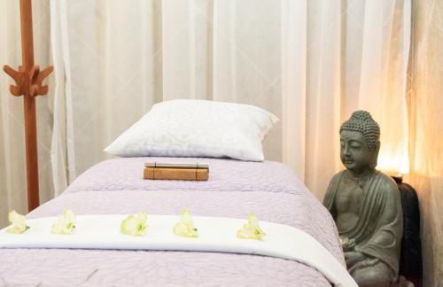 a statue sitting next to a bed with ducks on it at Hotel Rio Atlixco in Atlixco
