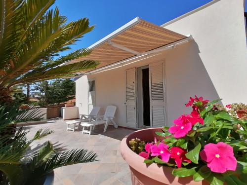 a villa with a view of a patio with pink flowers at Casa Vacanze Villa Tropia in Camastra ex Solfara