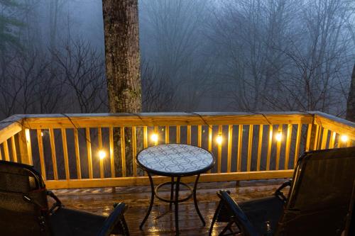 a table on a deck at night with lights at Pinetop Nest: Happy Place in Sugar Mountain in Banner Elk