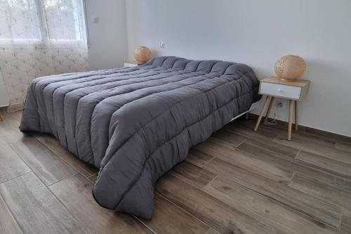 1 cama grande en un dormitorio con suelo de madera en CASA KHAMSA avec piscine privée, en Le Boulou