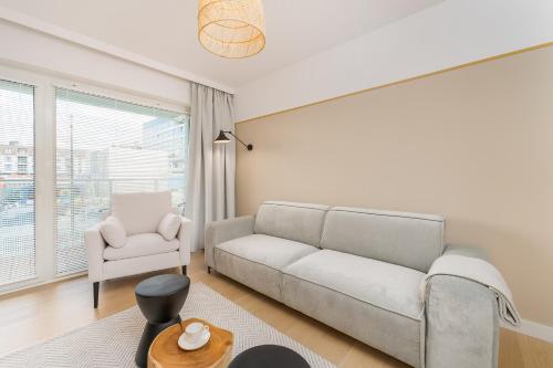 a living room with a couch and a chair at Aqua Polanki Bodnar Apartments in Kołobrzeg
