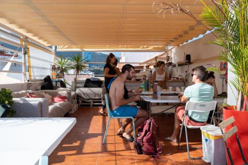 a group of people sitting at a table in a restaurant at Puerto Nest Hostel in Puerto de la Cruz
