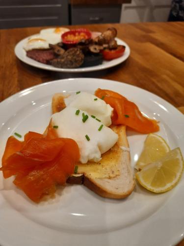 a white plate with food on a wooden table at Highlander House B&B in Rothesay