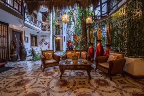a living room with couches and vases on the wall at Posada Mariposa Boutique Hotel - 5th Avenue in Playa del Carmen