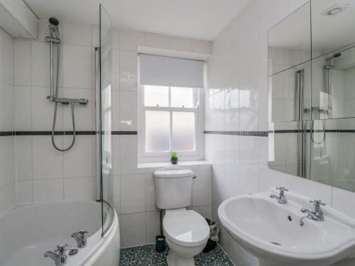 a bathroom with a toilet and a tub and a sink at 21 Entry Lane in Kendal