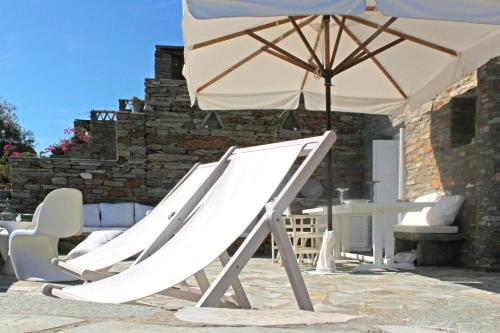 a slide and an umbrella on a patio at Romantic and cozy house on the waterfront in Koundouros, Kea in Koundouros