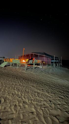 a building on the beach at night at Sunrise Desert Local Private Camp in Bidiyah